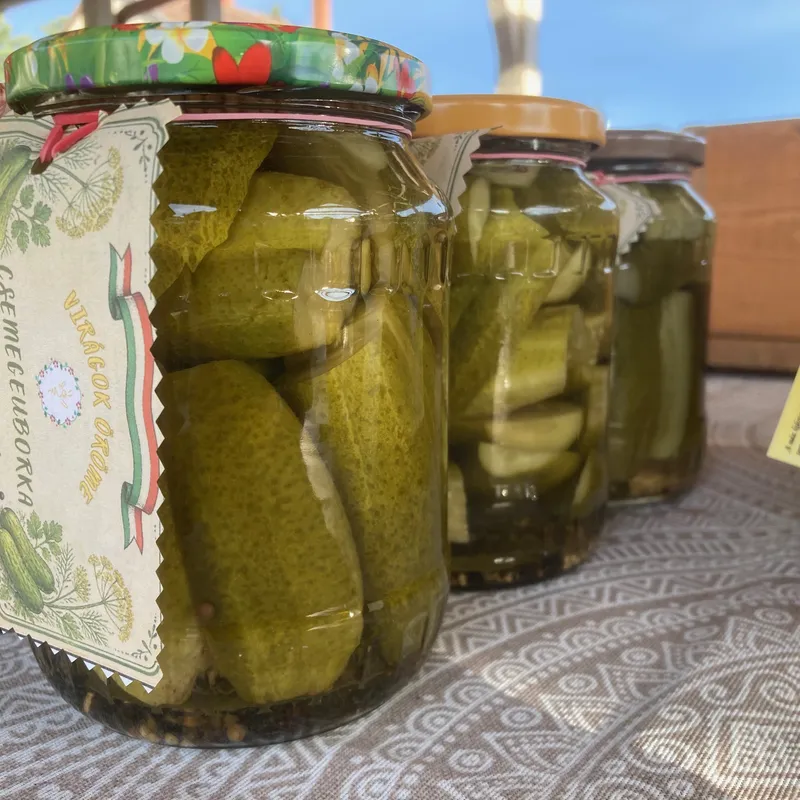 Házi csemegeuborka befőttesüvegekben egy piaci asztalon
